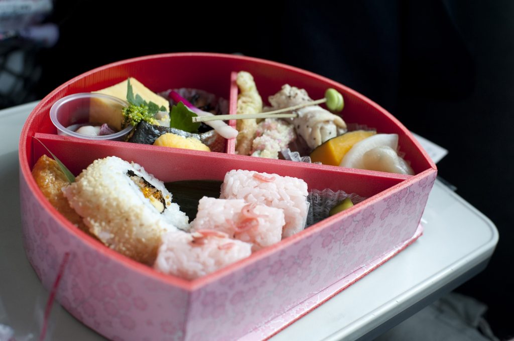 Serving of food inside a bento box, a lacquered container with internal divisions to house a complete traditional Japanese meal